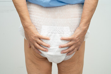Asian elderly woman wearing diaper for loss of bladder urinary incontinence control.