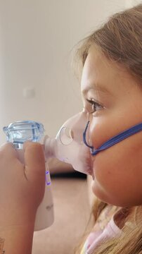 6 years old girl with nebuliser breathing medications. Close-up treatment of Adenoiditis, asthma, cough 