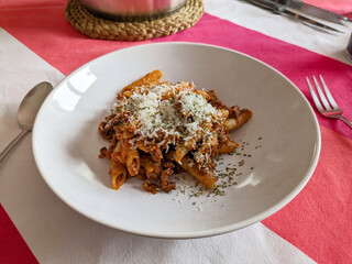 Dish with macaroni tomato and grated cheese