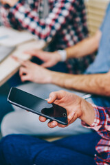 Cropped view of woman's hand holding modern smartphone device and typing with finger on display text to send message.Hipster girl updating profile on mobile phone using 4G internet connection