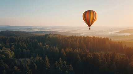 Obraz premium Hot air balloon in the sky above the forest landscape, place for nature travel