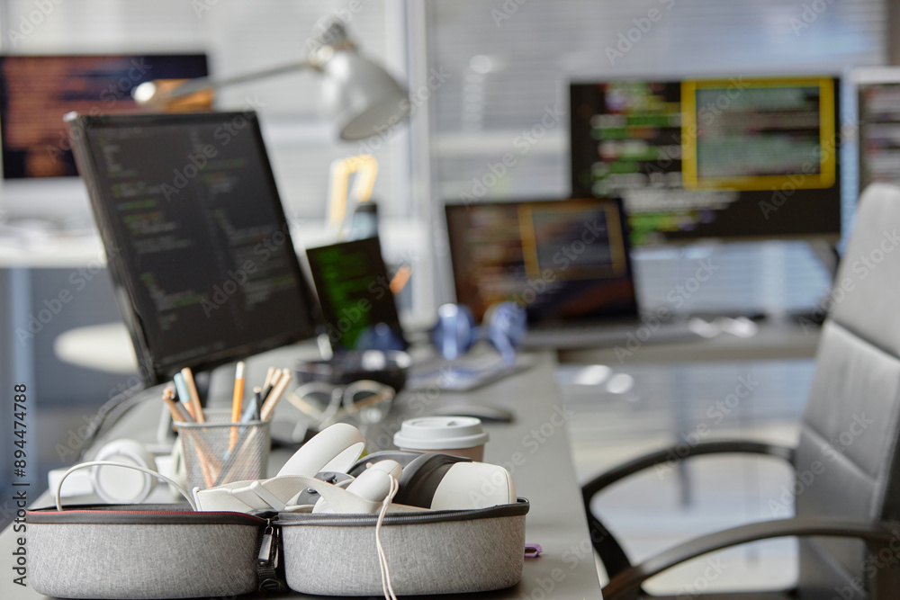 Poster background shot of contemporary computer programmer office setup with vr headset in carrying case on