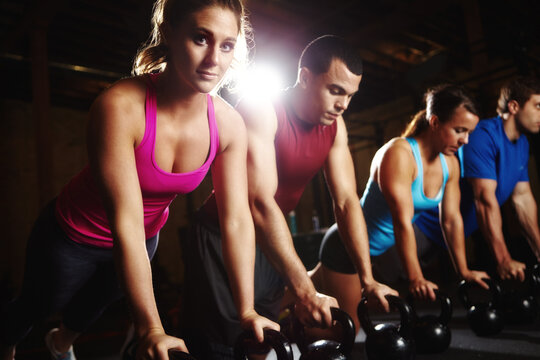Push up, woman and man in portrait with dumbbells, support and commitment to body workout. Bodybuilder, group and people together in exercise class with kettlebell, power training and teamwork in gym