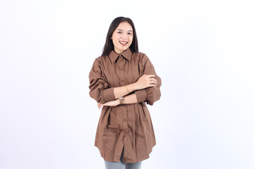 Cheerful Asian woman with confident smile looking at camera wearing brown dress both arms crossed isolated white background