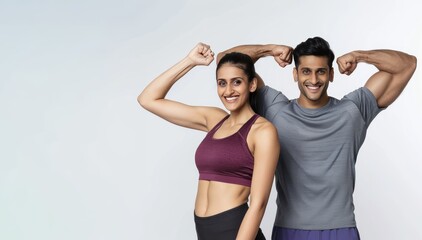 An Indian couple wearing athletic wear smiling while flexing their muscles against a white background, muscle flexing, athletic couple, fitness
