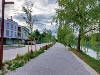 sidewalk near river Drava in Maribor. River embankment. Europe. Clouds. Summer