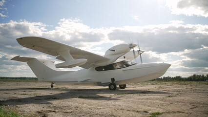 White small plane on the runway. There is a small sports plane on the runway. Single-engine turboprop aircraft. Small propeller plane on the airfield in summer. © Ruslan
