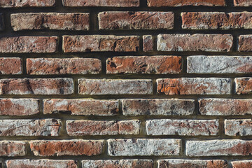 The old brick wall is damaged by time. A brick wall of a castle or an old house