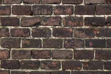 The old brick wall is damaged by time. A brick wall of a castle or an old house