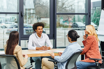 Group of professionals engaged in a meeting around a table in an office setting.