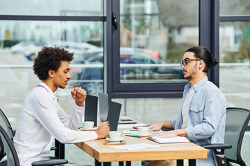 Two men engaged in a lively conversation at an office table.