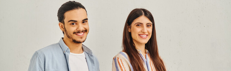 A man and a woman stand close, sharing a tender moment by a chair.
