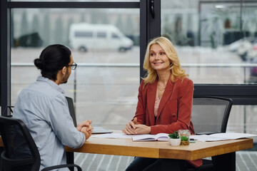 Job seeker interviewing at a modern office desk by woman.