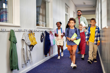 School kids walking in hallway with teacher
