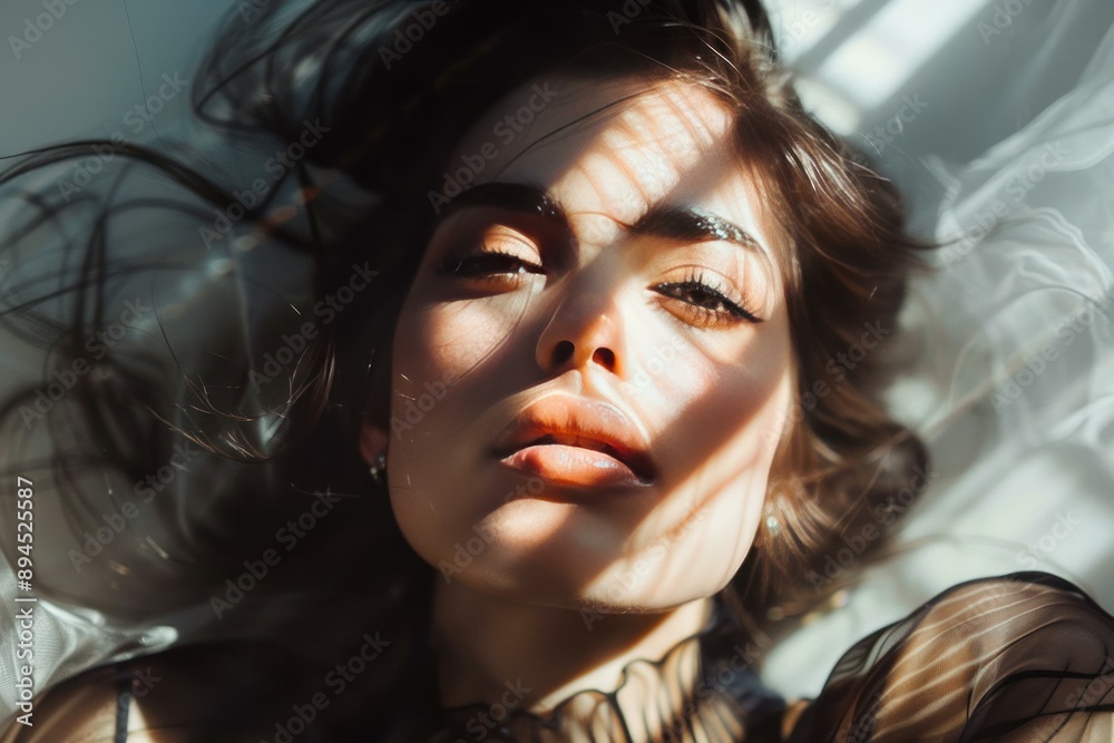 Poster Closeup of a mysterious womans face with hair flowing, illuminated by natural sunlight