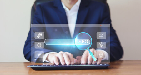 SEO concept. A businessman use computer and presses the button with an SEO icon for optimizing your...