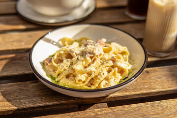 Pasta carbonara on plate in summer cafe