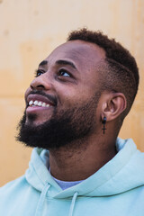 Fototapeta premium Portrait of cheerful bearded black man over yellow wall