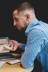 Couple in love solving problem during dispute during meeting in cafe at modern laptop device.Young woman arguing with boyfriend during discussion of shopping online on digital computer in cafeteria