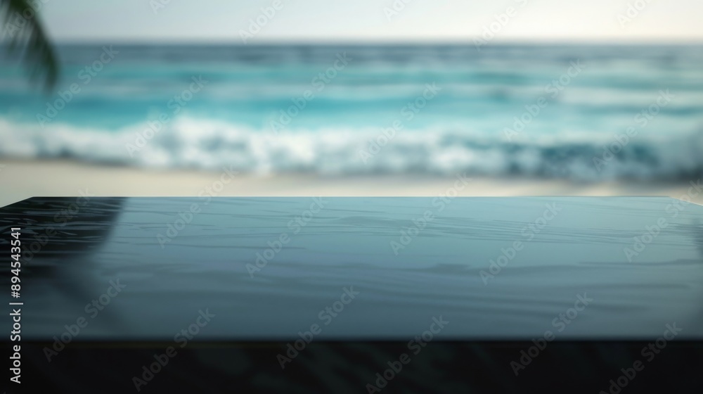 Poster a black tabletop with a blurred background of ocean waves and beach.