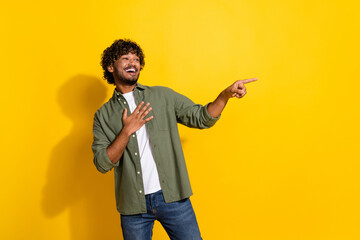 Portrait photo of young latin guy in khaki shirt touch chest laughing showing finger comic concert isolated on yellow color background