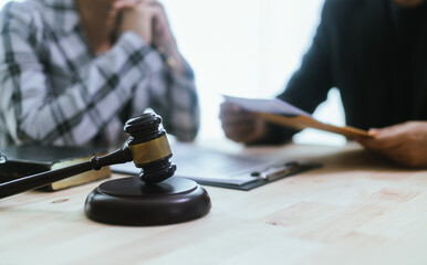 In a lawyer's office, a businessman consults an attorney for legal advice on a contract. The gavel...