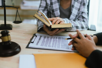 In a lawyer's office, a businessman consults an attorney for legal advice on a contract. The gavel symbolizes authority and justice. The lawyer explains the legislation and provides guidance on the ag