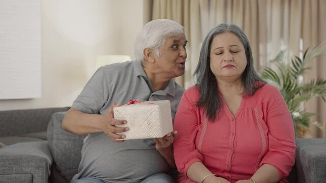 Happy Old Indian husband surprises wife with a gift