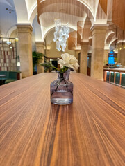 small glass vase with white flower in the lobby of hotel . High quality photo