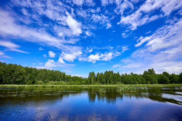 Fototapeta premium Beautiful summer river at sunny day with clouds reflection in the water
