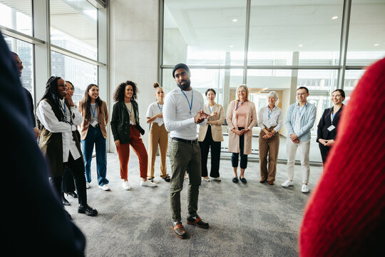 Instructor leading a team building exercise at a conference with diverse group