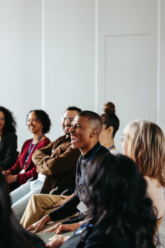Businessman laughing during a seminar with diverse group of people