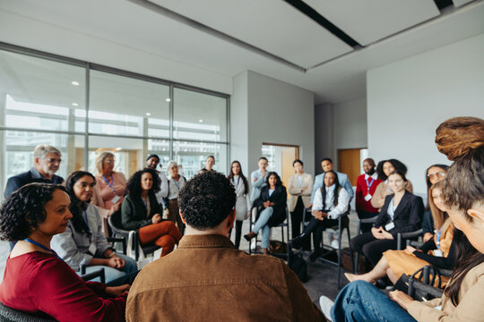 Diverse group of colleagues participating in a corporate event meeting in modern office setting