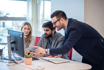 Business professionals collaborating on investments and teamwork, using a computer during a meeting, and working in partnership on the stock market.