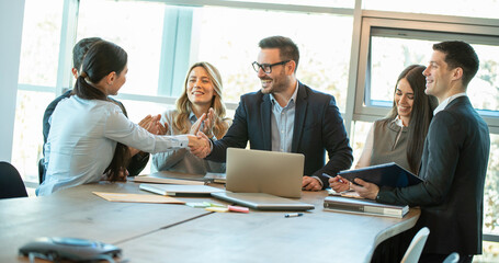 Group of business people, led by the manager, welcoming the new employee in the company.