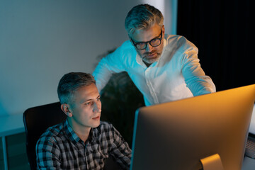 Two Men Collaborating On A Project In An Office, Showing Teamwork And Professionalism