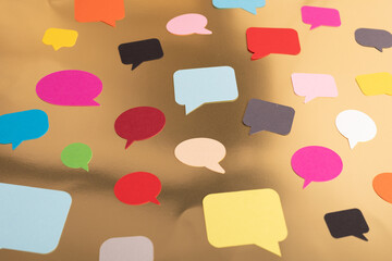 Colorful speech bubbles scattered on a gold surface