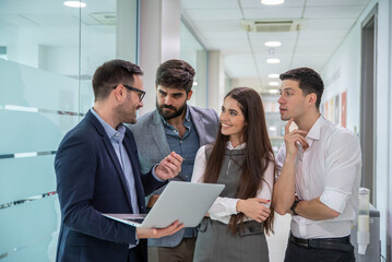Group of business people going over document on a laptop at office hall.