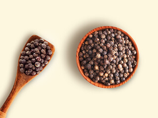 Black pepper or peppercorns in wooden bowl with spoon isolated on white background , top view , flat lay.