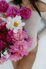 beautiful girl holding a bouquet of peonies