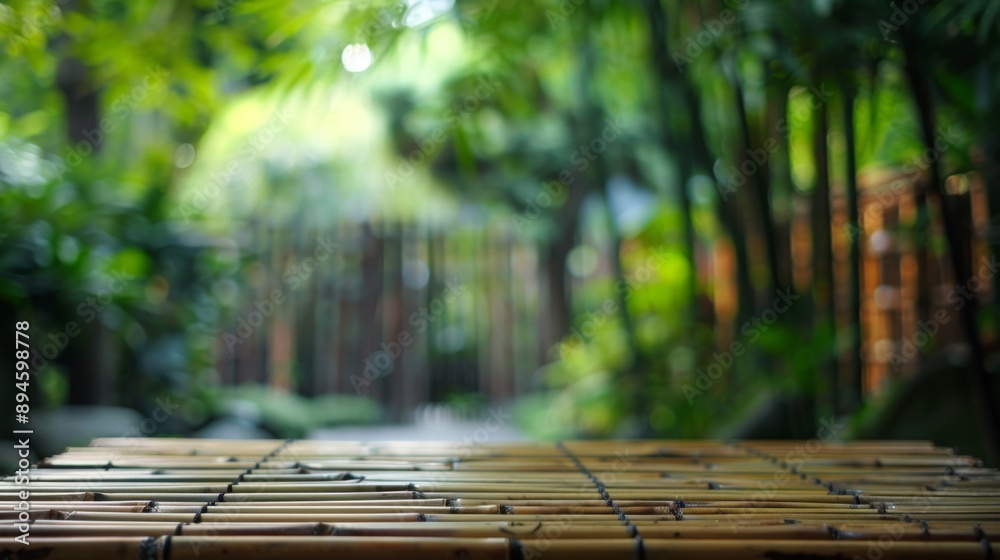 Poster a wooden table with a bamboo surface sits in front of a blurred background of green foliage.