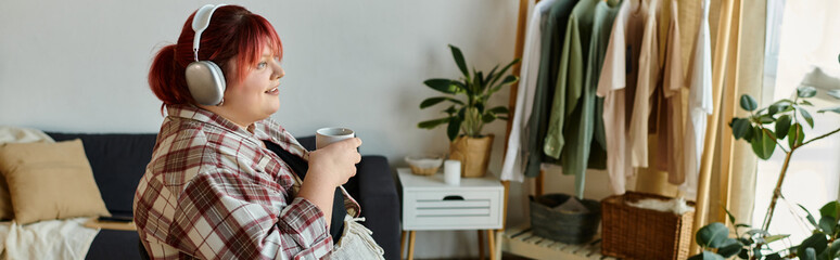 A woman in a plaid shirt listens to music while enjoying a beverage in her living room.