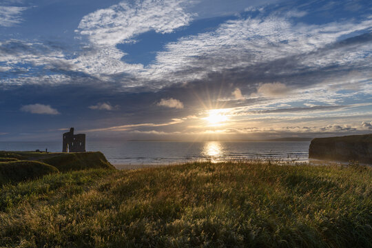 A castle ruins looking over the ocean coastline in Ireland