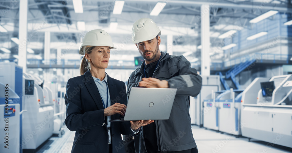 Poster Caucasian Male Engineer and a Female Technician Having a Conversation and Using Laptop Computer. Specialists Monitoring, Analyzing Conditions at a Modern Electronics Factory with Heavy Machinery