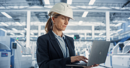 Portrait of a Happy and Smiling Caucasian Female Industrial Engineer in White Hard Hat Standing...