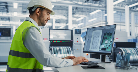 Electronics Factory: Caucasian Male Electrical Engineer Designs PCB Prototype, Works on Desktop...