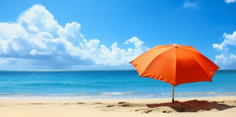Fototapeta premium Bright orange umbrella on a sandy beach with a clear blue sky and ocean backdrop, perfect for summer vacation themes