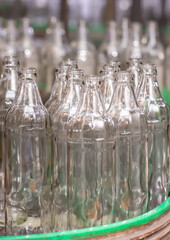 Glass factory, production of glass containers. Molten glass is blown into molds. Robotics in industry. Modern technologies, robotic machines produce products. Technological work at the plant.