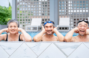 Three of senior people posing at camera at poolside,healthy elderly family and friend enjoy swimming in resort and spa on summer trip