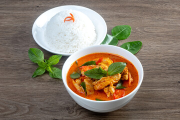Chicken red curry over rice on the wooden table